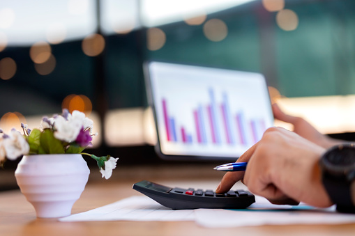 Close up of man checking on incomes, using calculator