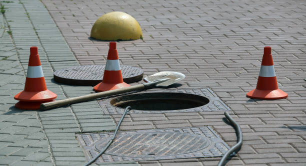 istock Open sewer hatch on the street near traffic cones. 1308089097