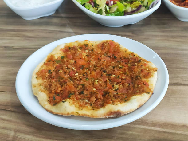 istock Lahmacun on white plate on wooden table 1308089335