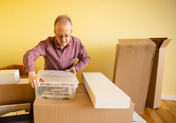 istock Middle aged caucasian man in empty apartment room, unpacking from cardbox boxes for moving house 1308094093