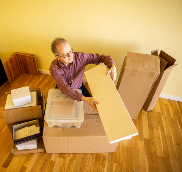 istock Middle aged caucasian man in empty apartment room, unpacking from cardbox boxes for moving house 1308094113