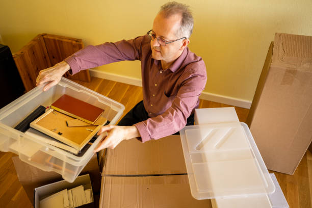 istock Middle aged caucasian man in empty apartment room, unpacking from cardbox boxes for moving house 1308094263