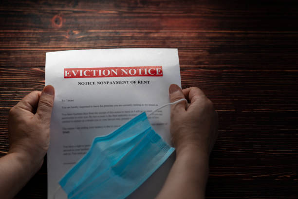 Eviction notice for non-payment during a pandemic. A woman holds an eviction notice for non-payment. Financial and housing problems during the lockdown. Free space for text. Partial blur. eviction photos stock pictures, royalty-free photos & images
