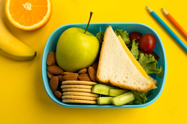 boîte à lunch sur le fond jaune. vue du haut. - lunch box lunch red apple photos et images de collection