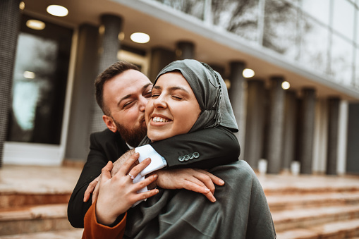 Modern Muslim Male Kissing Beautiful Wife Wearing Hijab Outside