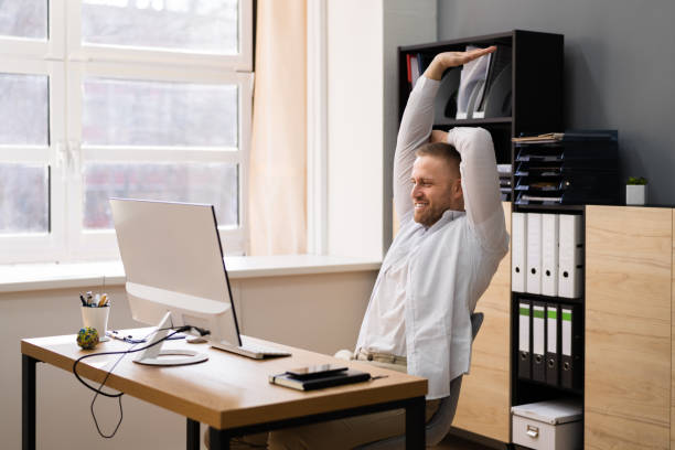 istock Stretch Exercise At Office Desk. Businessman 1308097404