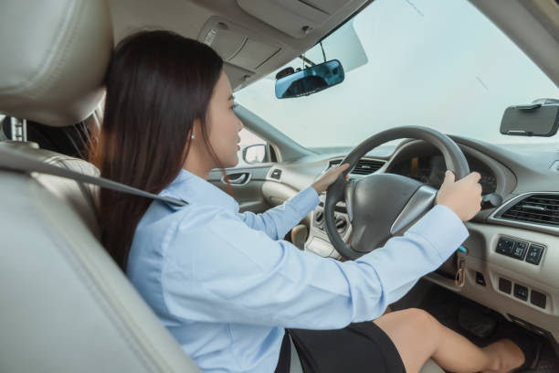 istock woman use mobile phone while driving a car. 1308099785