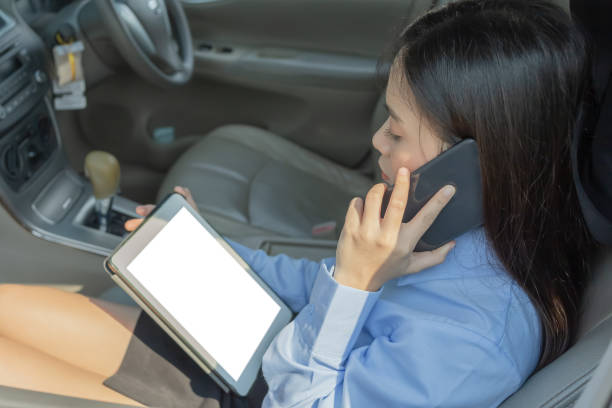 istock Businesswoman inside a car using a tablet and mobile phone for working. 1308100031