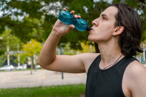 istock Aerobic exercise concept. Thirsty man having a rest drinking a bottle of water 1308103712