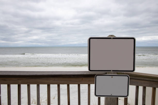 A blank sign with the ocean in the background on a cloudy day