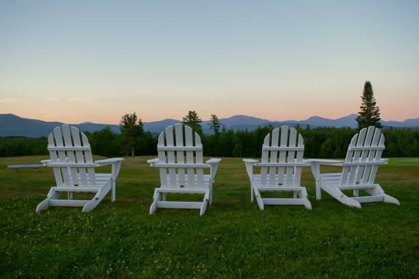 istock Empty Adirondack chairs looking out on a mountain sunset 1308107973