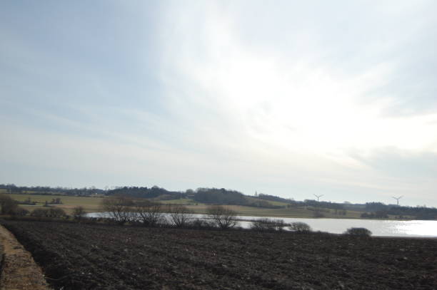 en regardant d’une voiture de conduite au-dessus d’un champ labouré à une vue d’un lac, d’un paysage roulant et d’un paysage nuageux. - patchwork landscape rolling landscape illuminated landscape photos et images de collection