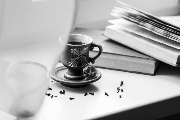 There is a beautiful coffee cup by the window.