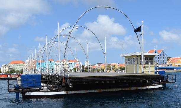 Queen Emma Bridge pontoon bridge across St. Anna Bay in Willemstad Queen Emma Bridge pontoon bridge across St. Anna Bay in Willemstad Curaçao; partially open with the colorful buildings of Otrobanda in the background willemstad stock pictures, royalty-free photos & images