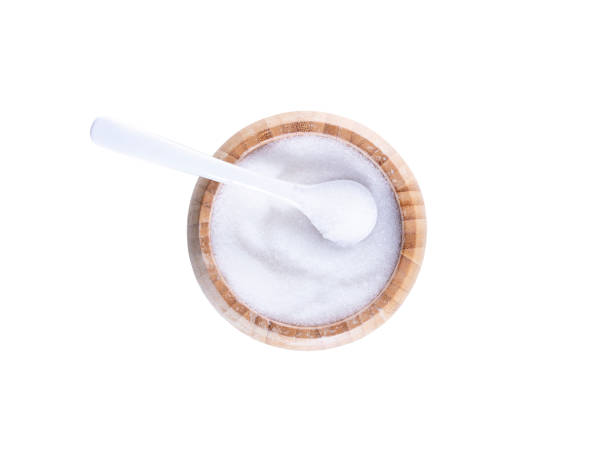 Fine granulated white sugar in wooden bowl isolated on white background Fine granulated white sugar in wooden bowl. Crystals of refined table sugar. Sweet soluble carbohydrates. Sucrose, disaccharide of glucose and fructose. Macro food photo close up from above over white crystalline inclusion complex stock pictures, royalty-free photos & images