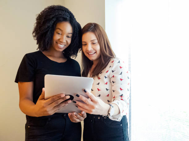 istock Two young women talking in an office. 1308113771