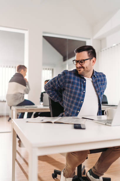 istock Businessman having back pain while sitting at the desk 1308113863
