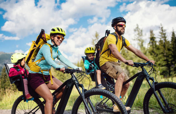 Family with small children cycling outdoors in summer nature, High Tatras in Slovakia. Happy family with small children cycling outdoors in summer nature, High Tatras in Slovakia. tatra tourists stock pictures, royalty-free photos & images