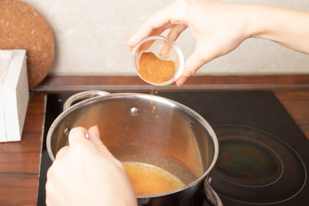 istock Women's hands add seasoning ginger cinnamon for making gingerbread 1308114897