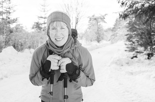 Mature woman resting during a hike over snow covered terrain.