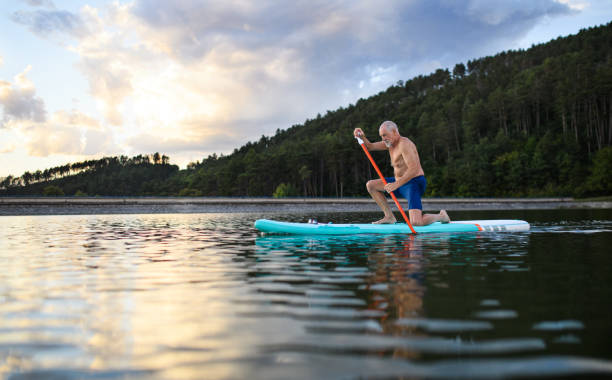 istock Senior man paddleboarding on lake in summer. Copy space. 1308116186
