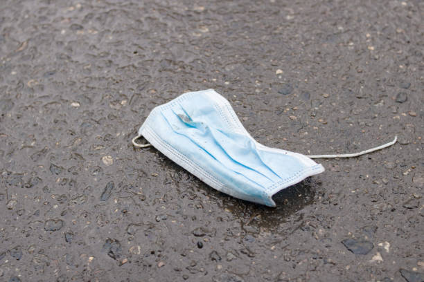 istock Old used medical mask on the asphalt 1308118075
