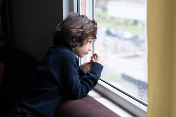 istock Portrait Of Schoolboy Looking Through Window 1308119201