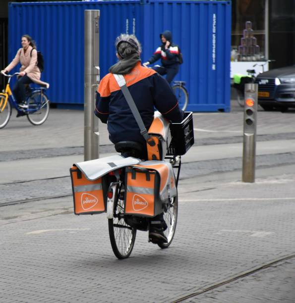 PostNL Delivery Worker Carrying Package To Clients With Bicycle During Winter Season In The Hague South Holland The Netherlands Europe