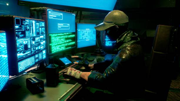 istock A male hacker surrounded by glowing monitors hacks into someone else's computer network in a dark room of his office. 3D Rendering. 1308121395