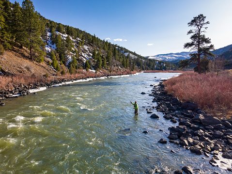 Fly Fishing Casting - Man fishing outdoors along scenic river.