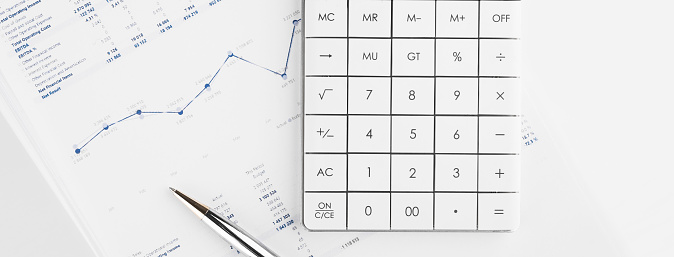 Calculator on financial statement and balance sheeet on desk of auditor. Concept of accounting and audit business.