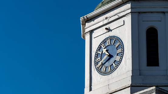 Clock tower in the city against a blue sky