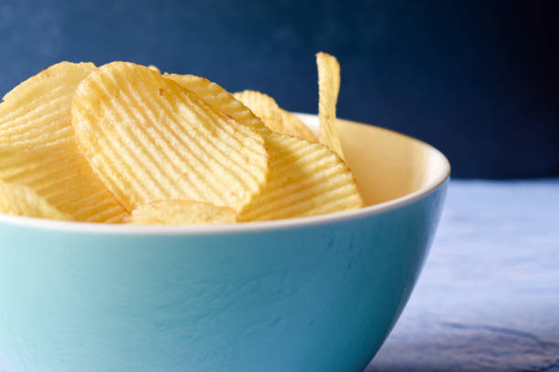 istock Potato chips in a bowl on a blue table 1308127353