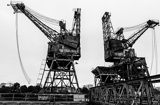 Wide-shot of two old metal cranes at Battersea Power Station against a clear sky