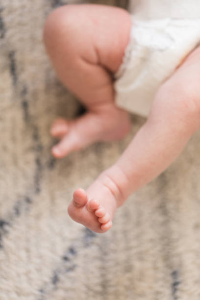 istock Newborn Baby Feet & Legs with a White Background 1308128431