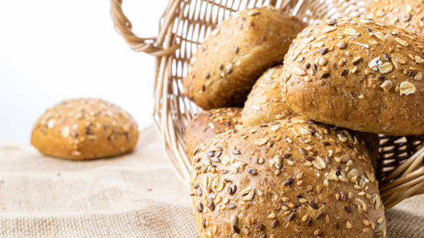 istock Rustic rye. Fresh loaf of rustic traditional bread with wheat grain ear or spike plant on linen texture background. Bakery with crusty loaves and crumbs. Design element for bakery product label. 1308128491