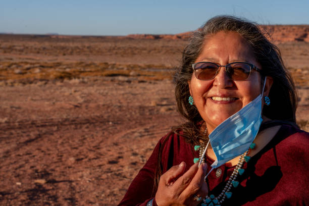 portrait of a beautiful native american woman smiling and removing her  mask, covid19, pandemic - native american north american tribal culture women mature adult imagens e fotografias de stock