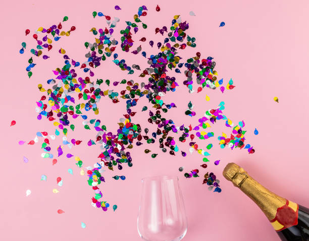 istock Wine glass and champagne bottle on pink background 1308137492