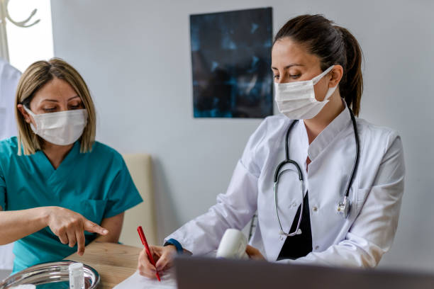 istock Female Doctor and nurse taking a not about her patients before session. 1308138451