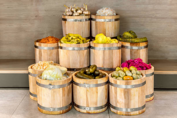 many pickled vegetables in wooden oak barrels side view, farmers market concept
