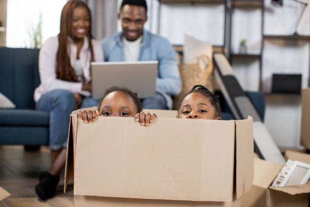 istock Two kids sitting inside cardboard box at new flat 1308144574