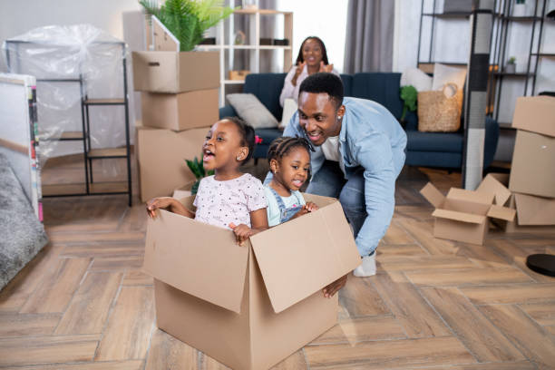 istock Father playing with daughters while mother working on laptop 1308144925