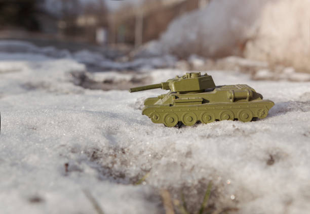 Toy metal tank rides in the snow