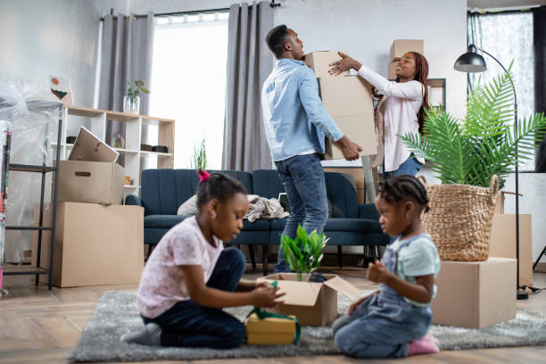 istock Afro couple packing boxes while kids playing on floor 1308145854