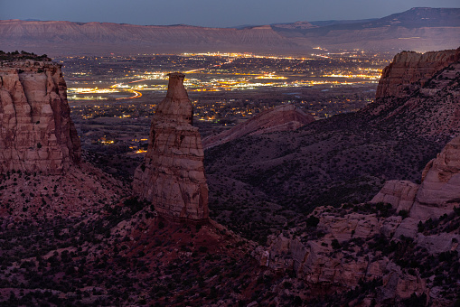With just enough moonlight to define the landscape at Colorado National Monument the city illuminates Fruita and Grand Junction below.