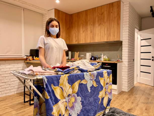 istock woman in flu mask ironing clothes 1308153417