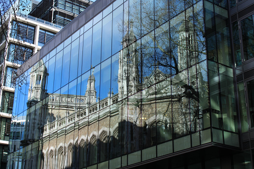 The Royal Courts of Justice, Rolls Building branch in London reflected in the glass of an office building