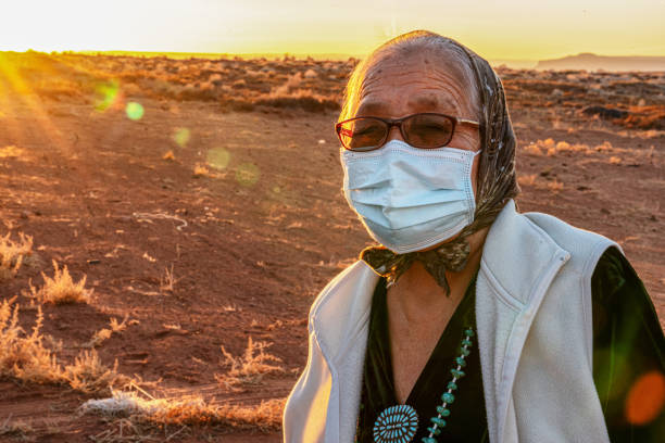 Elderly Native American Woman Wearing A Mask To Protect Her From Covid-19, Near Her Home In Monument Valley Utah Elderly Native American Woman Wearing A Mask To Protect Her From Covid-19, Near Her Home In Monument Valley Utah navajo nation covid stock pictures, royalty-free photos & images