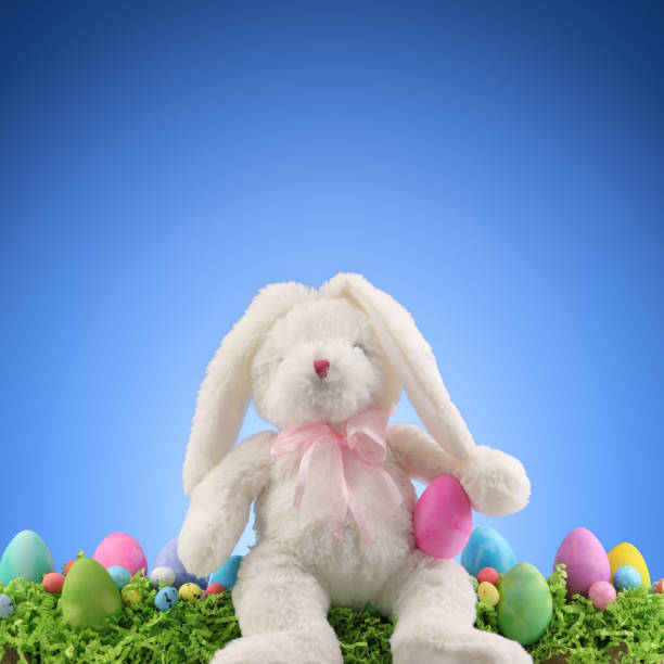istock Stuffed animal Easter Bunny surrounded with painted Easter eggs and colorful decorations. Copyspace for text. 1308157624