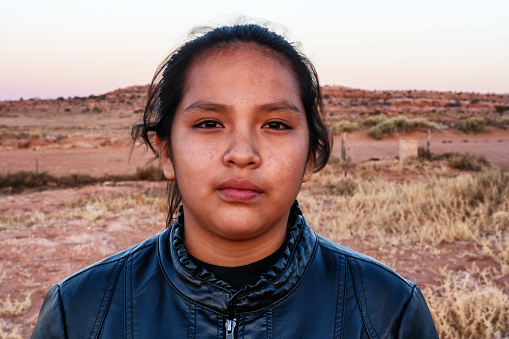 Un retrato de cerca de una joven navajo nativa americana cerca de su casa en Monument Valley, Utah photo